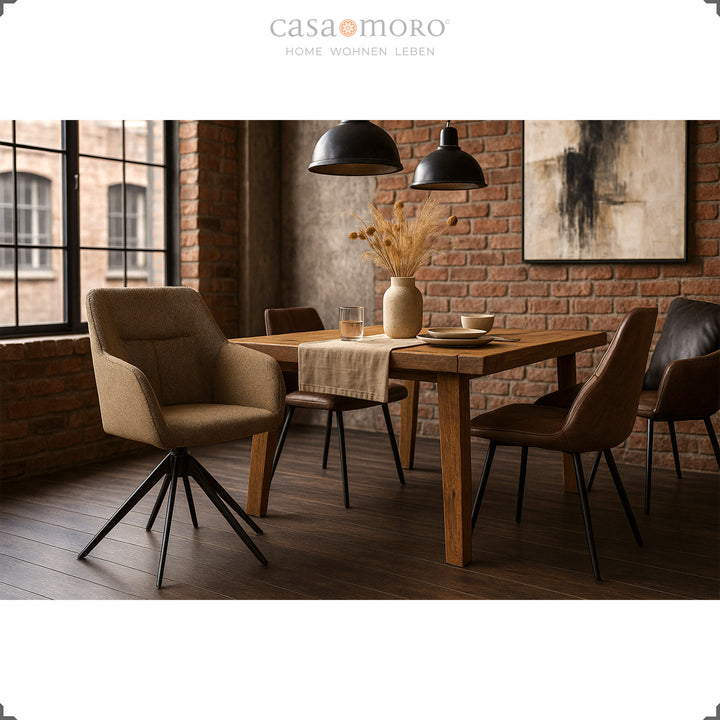 360° drehbarer Polsterstuhl mit Armlehnen in Braun an einem Holztisch in modernem Esszimmer mit Backsteinwand und schwarzen Pendelleuchten