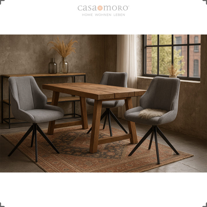 Drei 360° drehbare Esszimmerstühle in Grau mit schwarzem Metallgestell um einen Holztisch in modernem Loftambiente mit Teppich und Dekoration