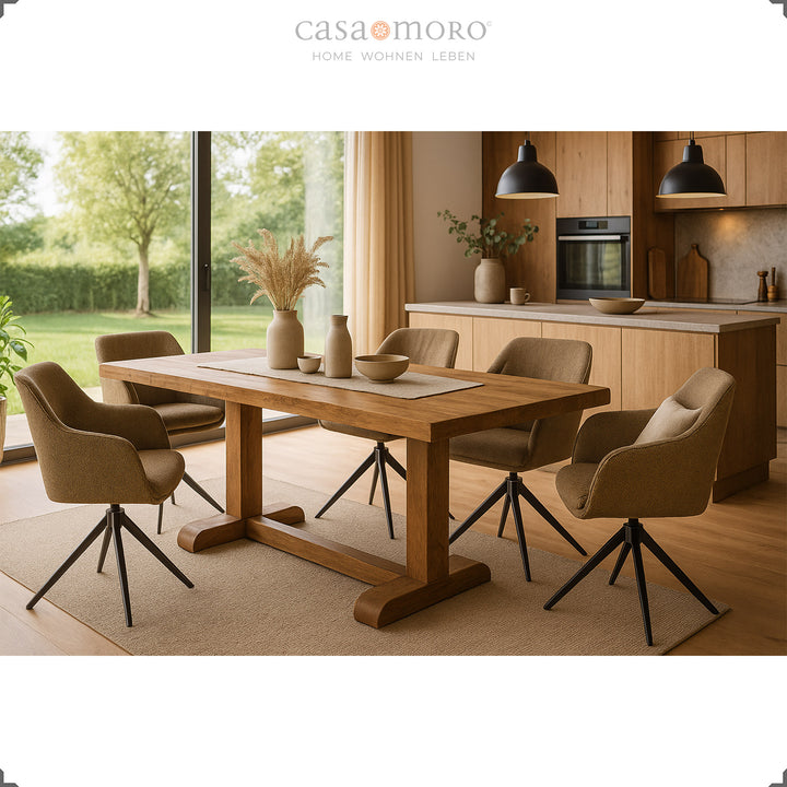 Vier 360° drehbare Polsterstühle mit Armlehnen in Braun um einen Holztisch in einer modernen Küche mit großen Fenstern und Blick ins Grüne