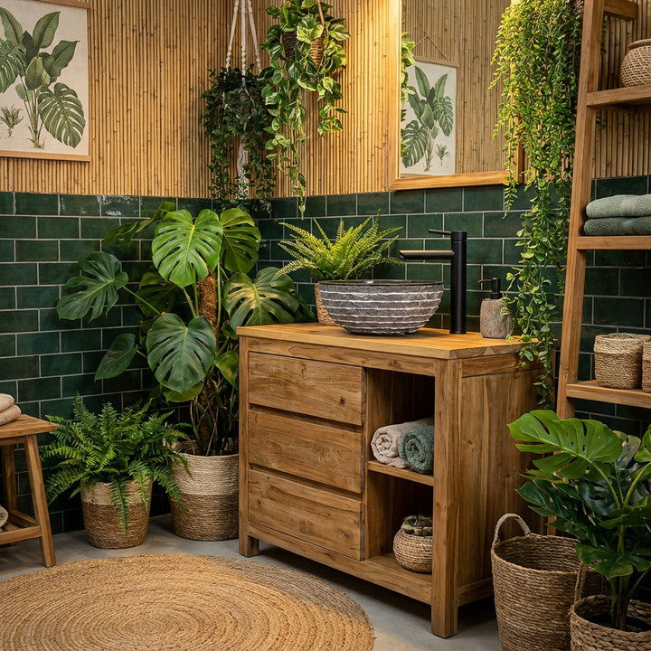 Round stone countertop washbasin on wooden vanity unit in green bathroom with plants, dark tiles and black fittings