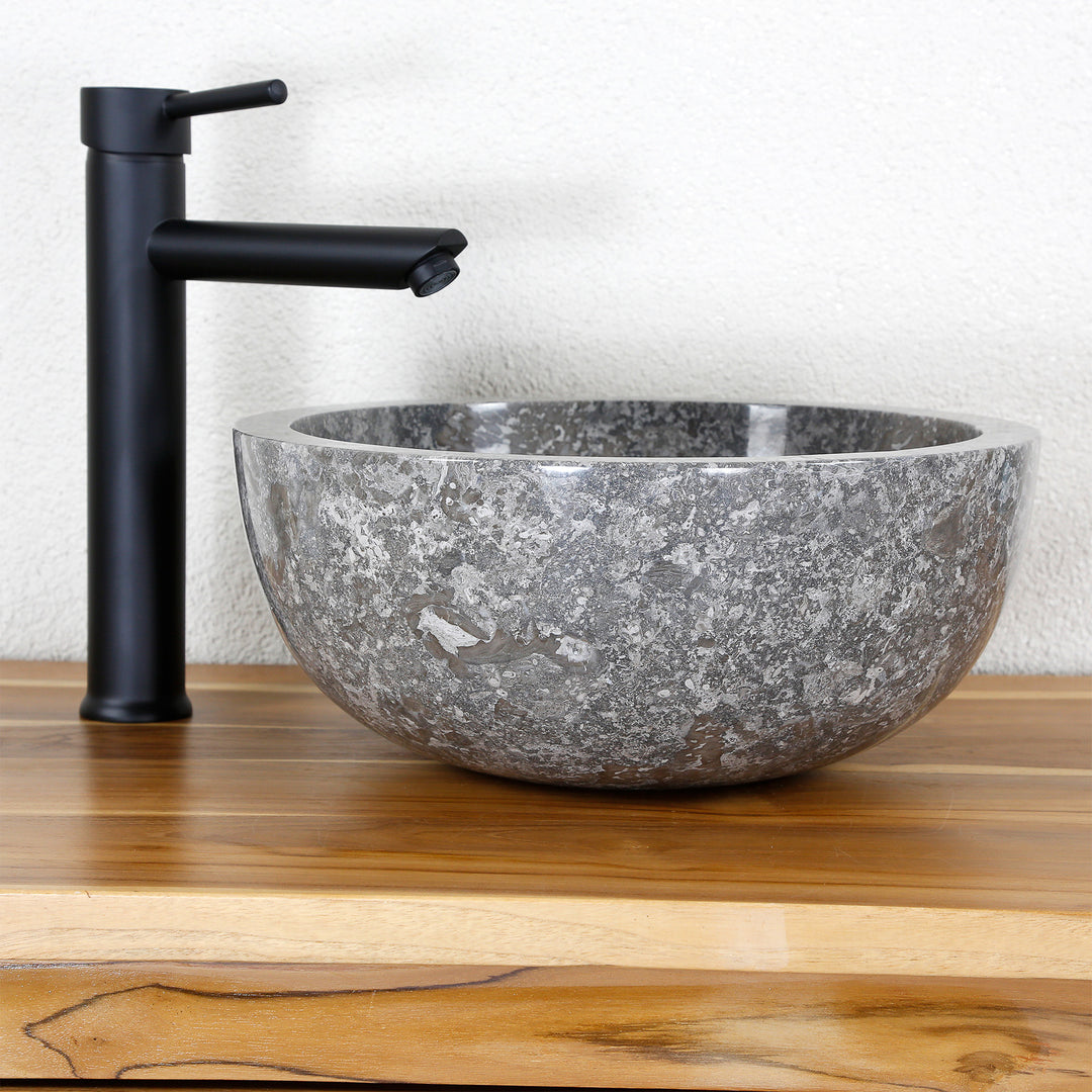 Round Washbasin Made of gray marble with polished interior, stone sink on wooden top with fitting