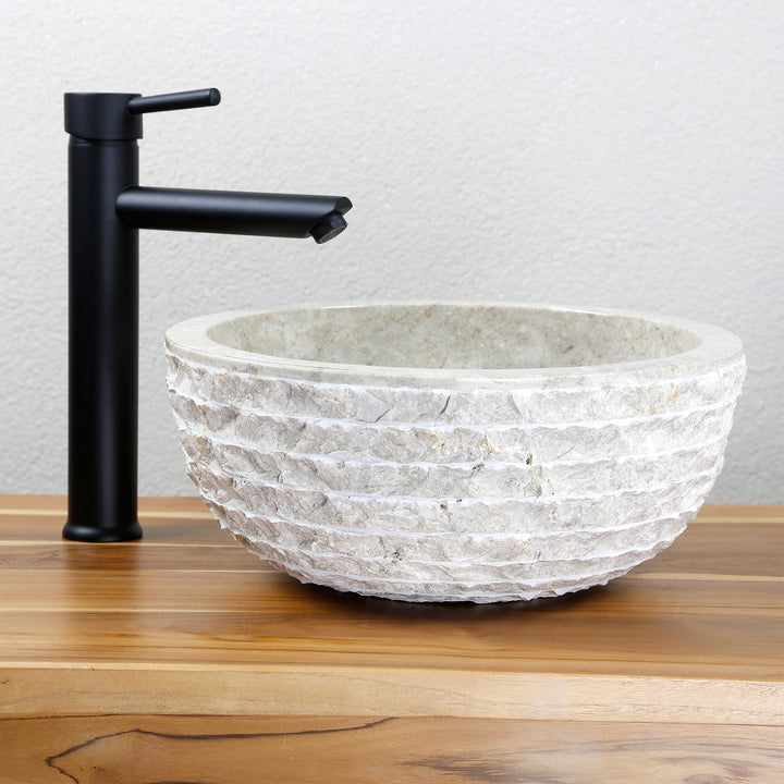 Round Washbasin Made of light natural stone with a structured outside as an attachment to a wooden top with a black fitting