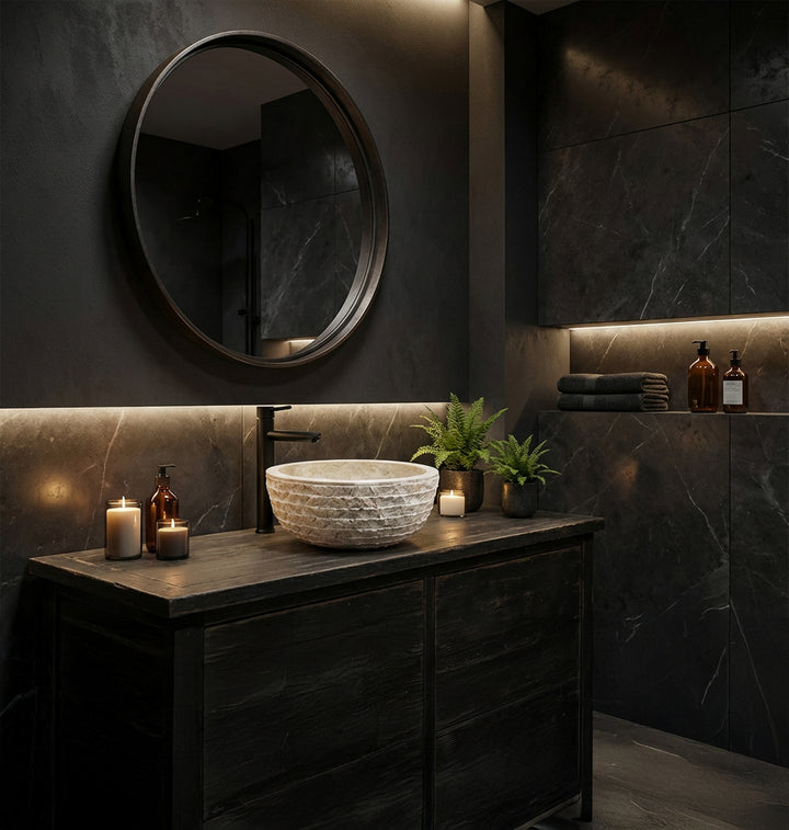 Elegant stone washbasin made of natural stone as a countertop basin on a dark vanity unit in the modern spa bathroom with candlelight