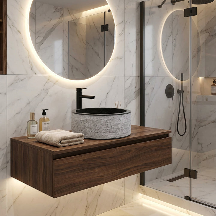 Round stone washbasin on a floating wooden console, modernly combined with black fittings in an elegant designer bathroom.