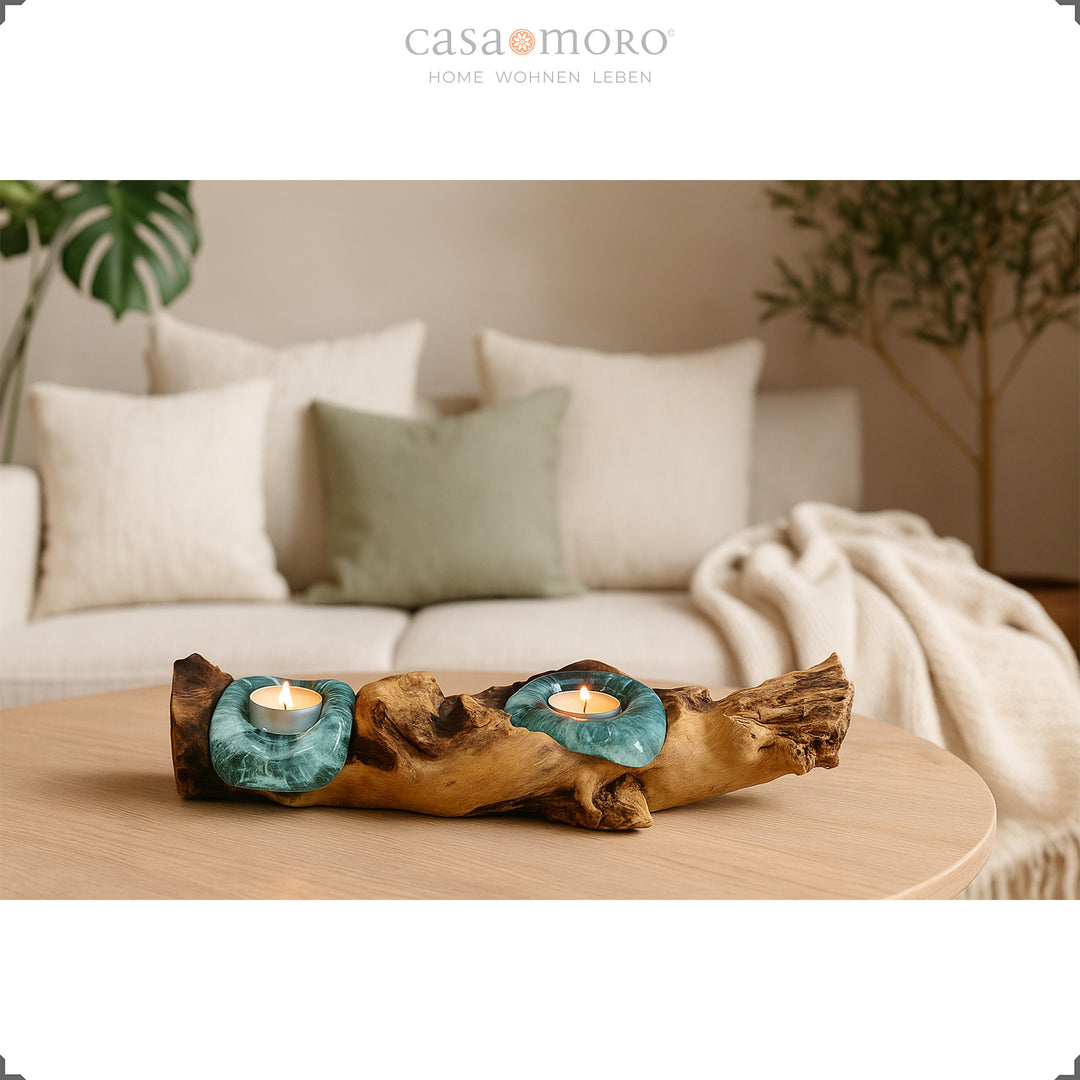 2er Teelichthalter aus Glas und Wurzelholz auf einem runden Tisch, sein sanftes Licht ergänzt das helle, gemütliche Wohnzimmer.