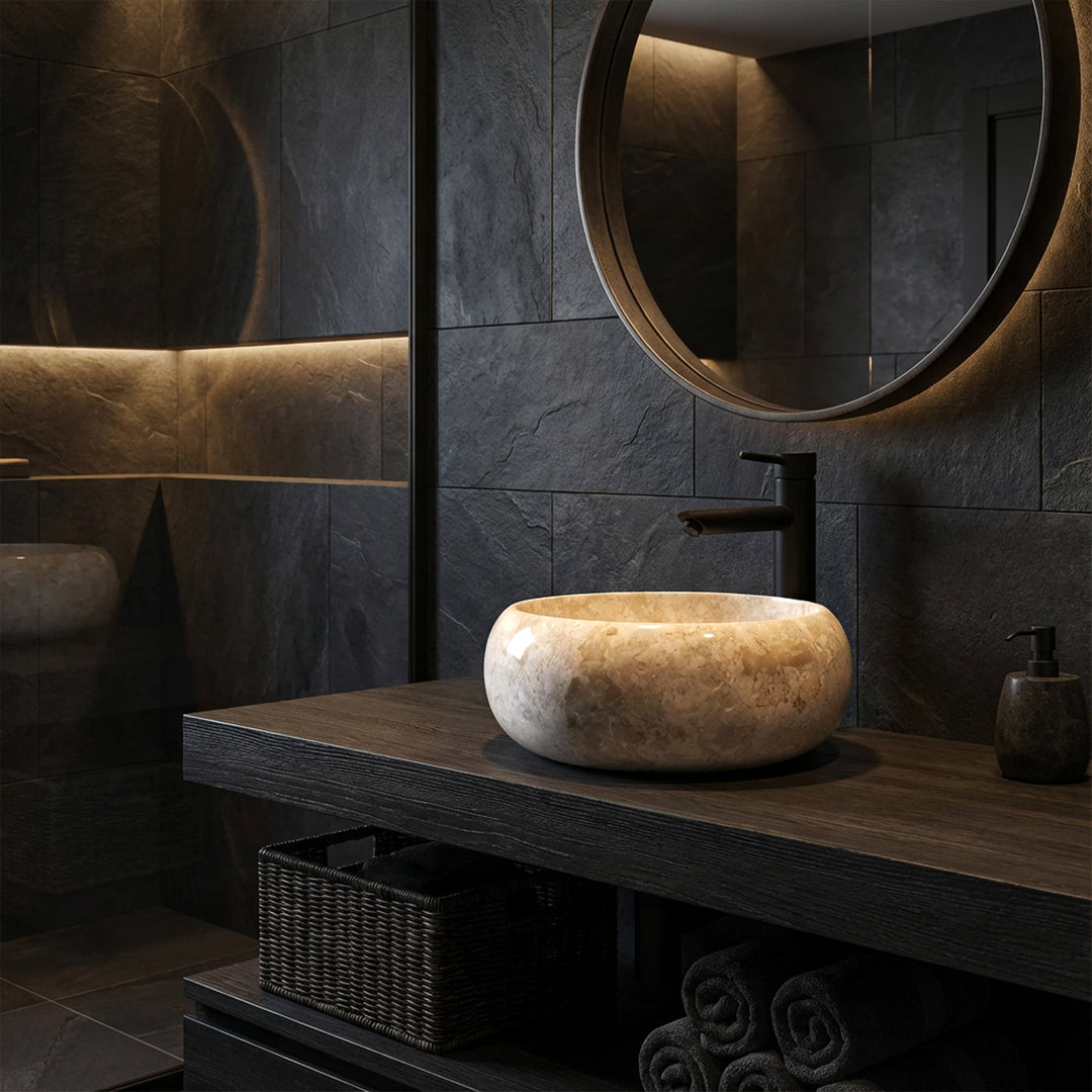 Round natural stone countertop washbasin on a dark wooden washbasin with black fittings in a modern, dark bathroom ambience