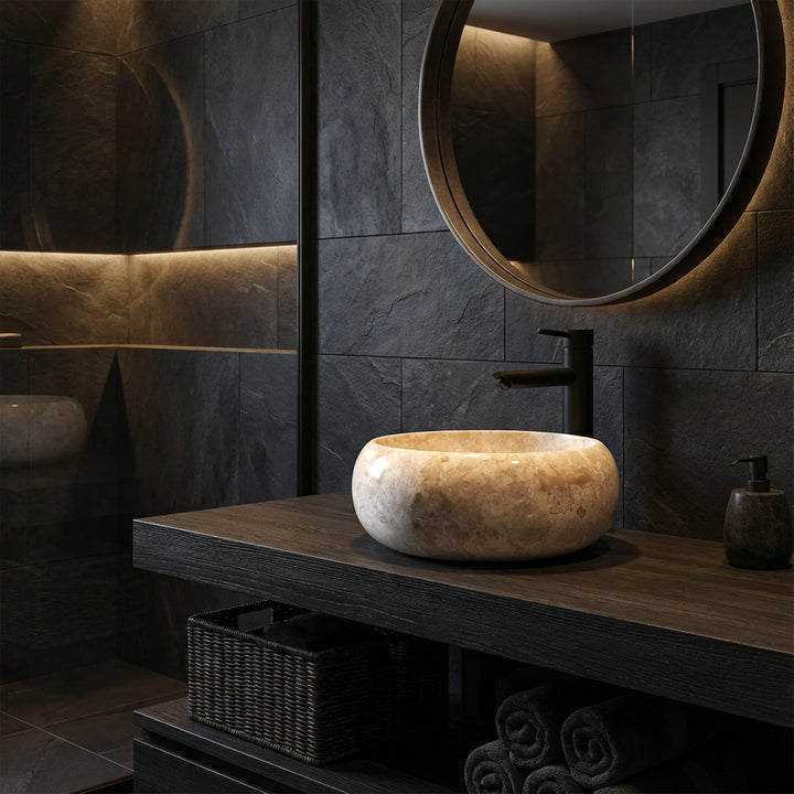 Round natural stone countertop washbasin on a dark wooden washbasin with black fittings in a modern, dark bathroom ambience