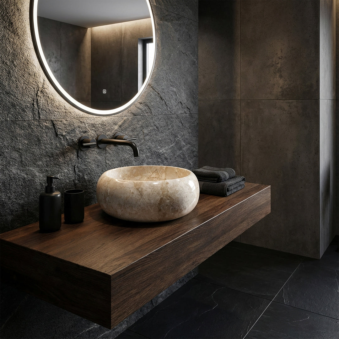 Round countertop washbasin made of light stone on a floating wooden washbasin with wall fittings in a modern, dark bathroom ambience
